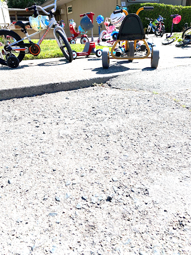 A collection of children’s bikes and tricycles lined up outside an East Bay preschool for Bike To Wherever Days.