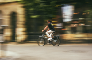 Cyclist riding an electric bike through a city street representing everyday e-bike commuting