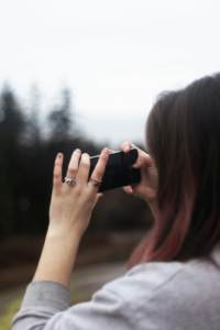 Person using phone to document scene after bicycle accident involving a dog